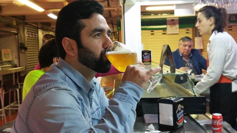 Person drinking a glass of beer